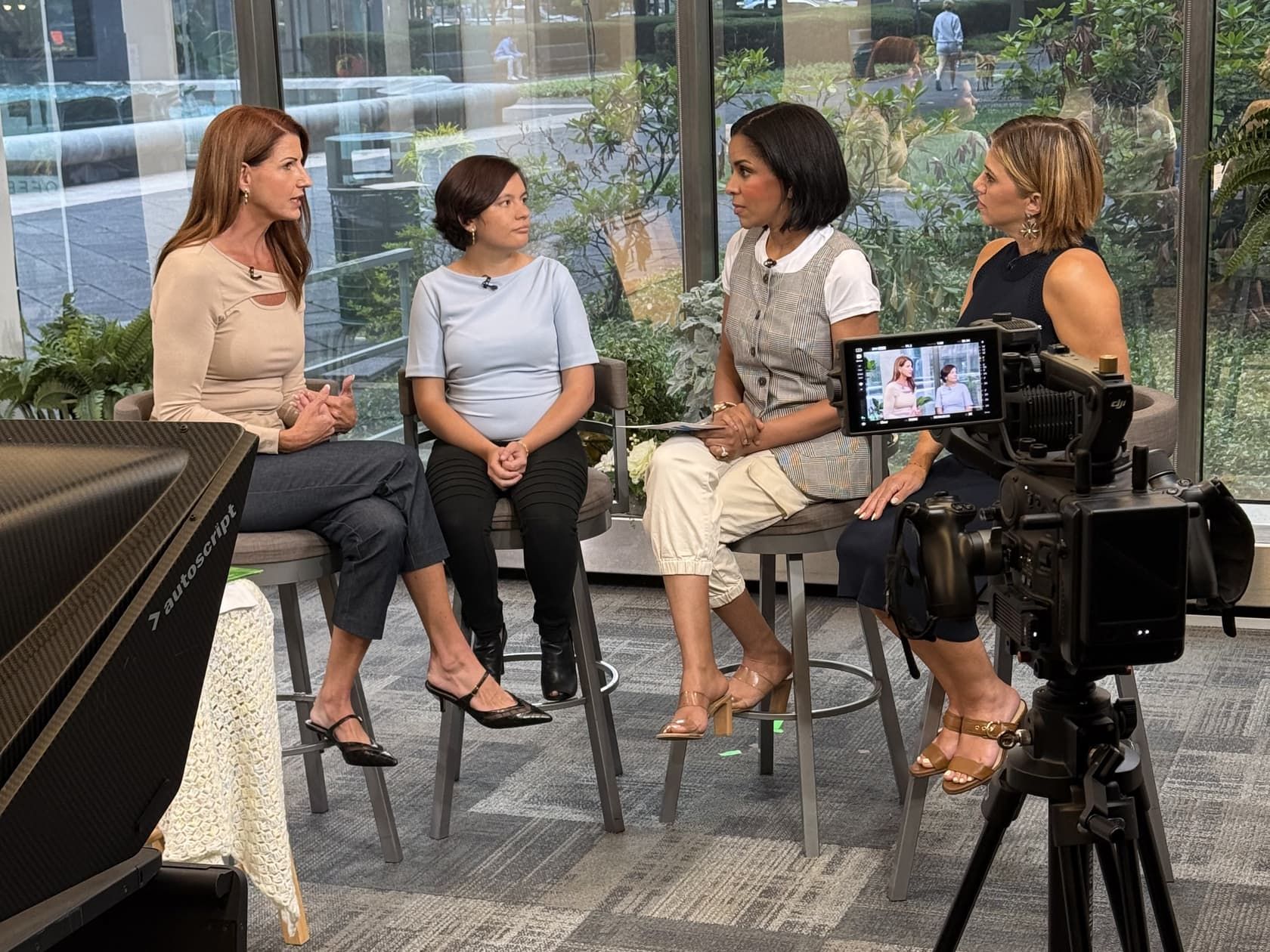 Suzanne Hobbs and her daughter Lillie being interviewed by two presenters in a Pittsburgh television studio, with a camera and teleprompter in the foreground.