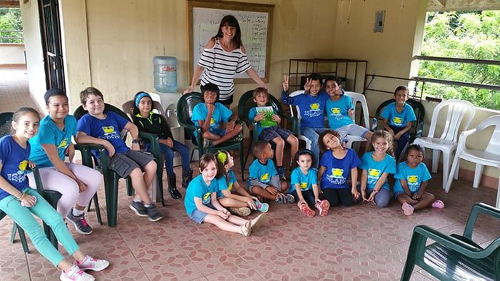 A classroom of children holding copies of The Hungry Snake, with Suzanne Hobbs standing behind them.