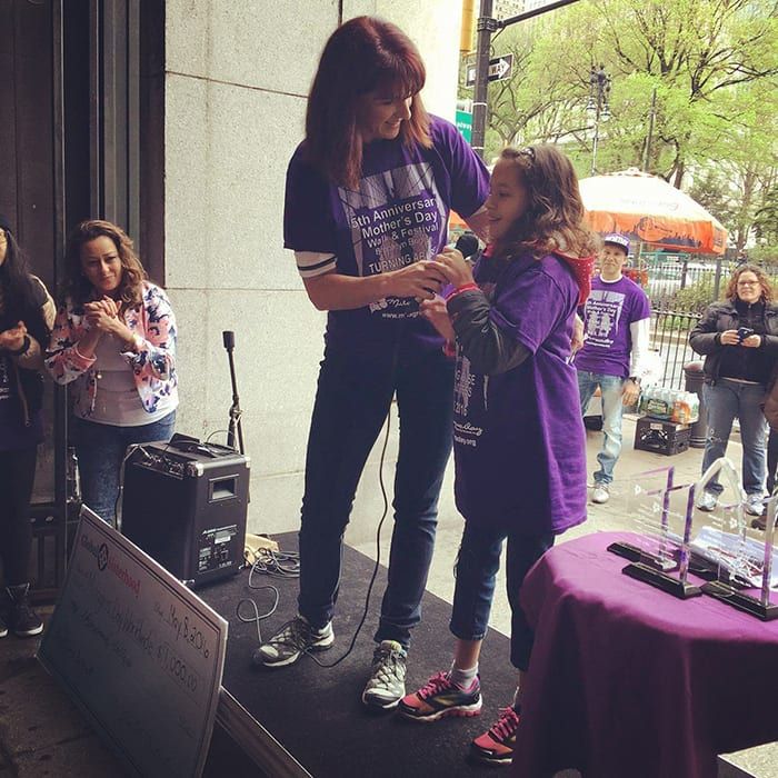 Suzanne Hobbs speaking from a podium at a Mother's Day rally in New York.