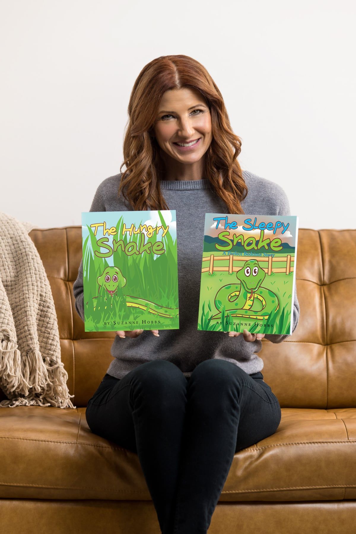 Suzanne Hobbs holding The Hungry Snake and The Sleepy Snake.